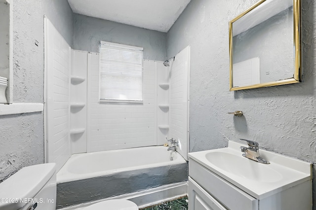 bathroom with vanity, toilet, and a textured wall