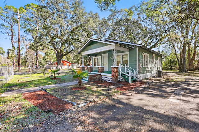 view of front of home featuring covered porch, central AC, and fence