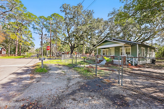 view of front of house with a fenced front yard, covered porch, and a gate