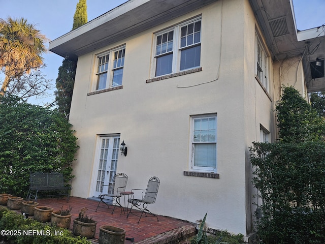 exterior space featuring stucco siding, a patio, and french doors