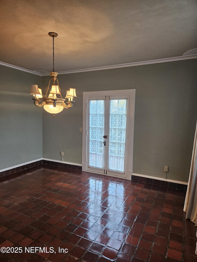 spare room featuring a notable chandelier, french doors, baseboards, and ornamental molding