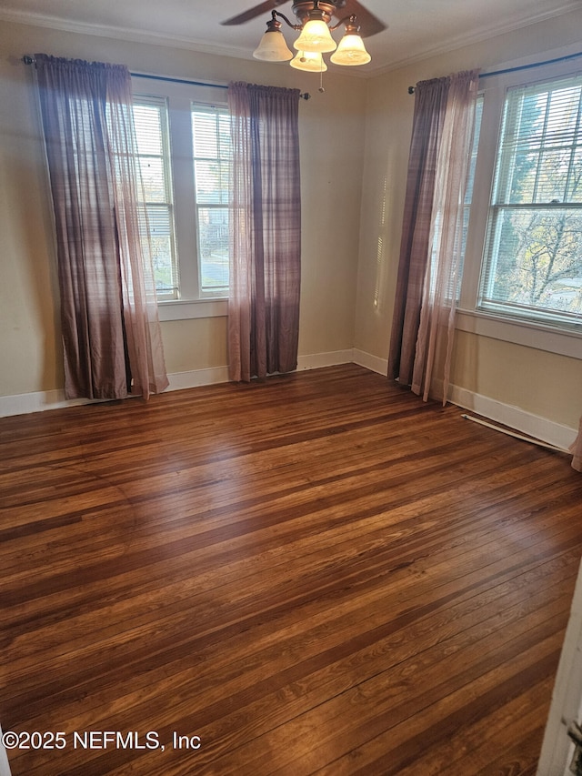 empty room with ceiling fan, wood finished floors, baseboards, and a healthy amount of sunlight