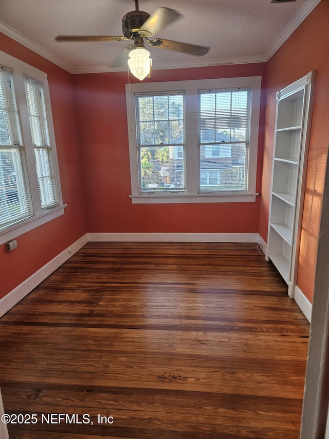 empty room featuring crown molding, wood finished floors, and ceiling fan