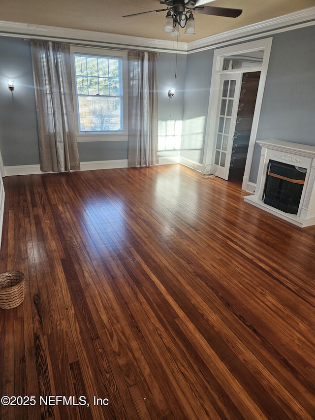 unfurnished living room with a fireplace with raised hearth, crown molding, baseboards, hardwood / wood-style flooring, and a ceiling fan