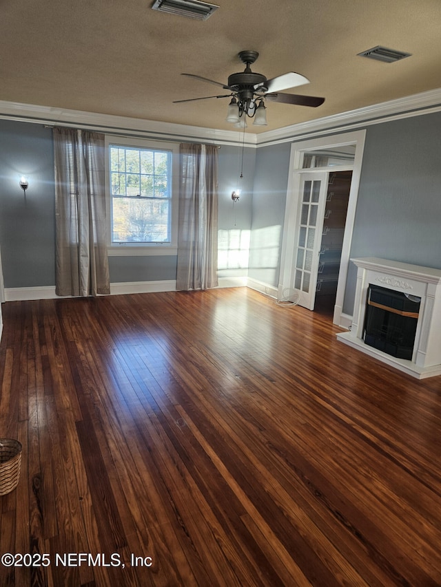 unfurnished living room featuring visible vents, a fireplace with raised hearth, a ceiling fan, hardwood / wood-style flooring, and crown molding