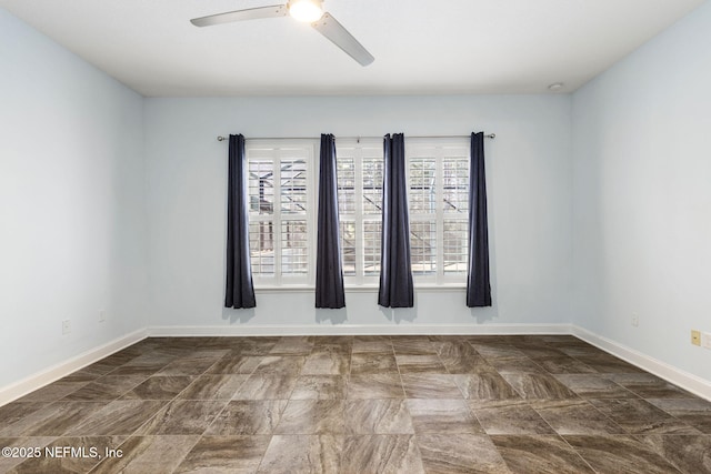 empty room featuring baseboards and ceiling fan