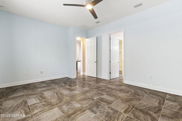 unfurnished bedroom featuring connected bathroom, visible vents, baseboards, and ceiling fan