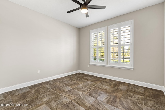 unfurnished room with ceiling fan and baseboards