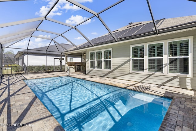 pool with glass enclosure and a patio area