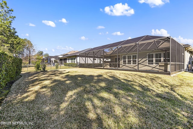 back of house with a lanai, a yard, a fenced backyard, and a patio area