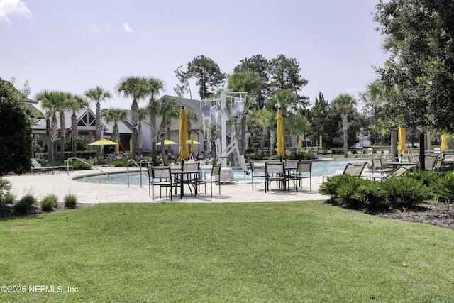 view of home's community with a patio, a lawn, and a pool