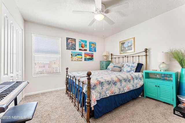 carpeted bedroom featuring ceiling fan, a textured ceiling, and baseboards