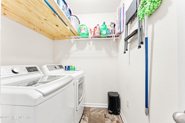 clothes washing area with laundry area, washing machine and dryer, and baseboards