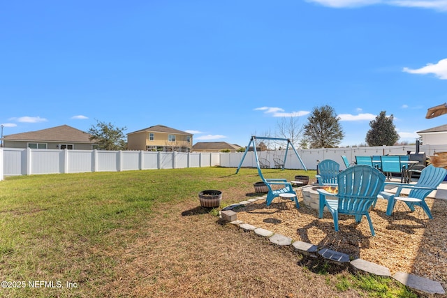 view of yard with a fenced backyard and a fire pit