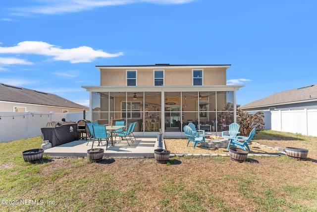 rear view of house featuring an outdoor fire pit, a patio area, a fenced backyard, and a sunroom