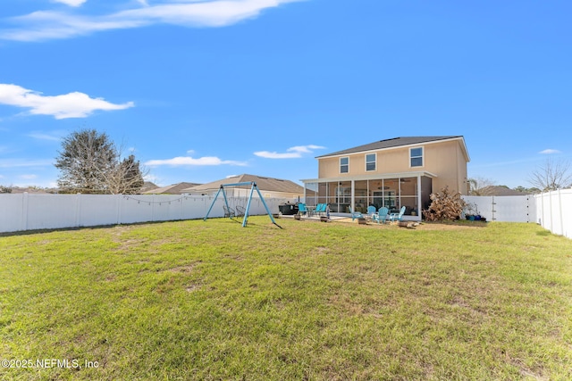 view of yard with a sunroom, a fenced backyard, a patio area, and a playground