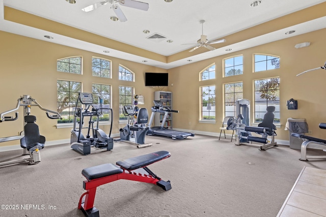 gym with baseboards, visible vents, and a ceiling fan