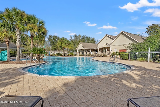 community pool with a patio and fence