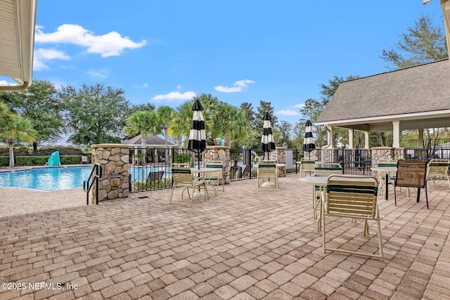 view of patio / terrace with fence and a community pool