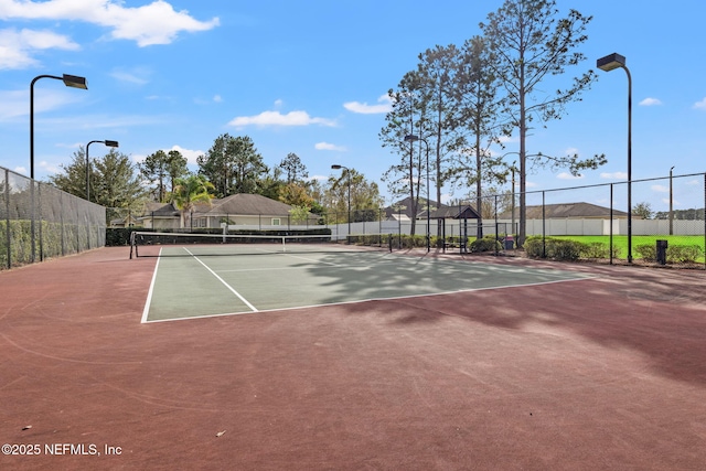 view of tennis court with fence