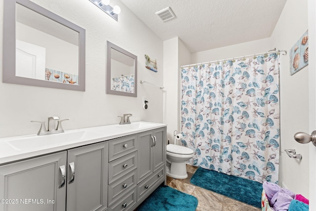 full bath with double vanity, visible vents, toilet, a sink, and a textured ceiling