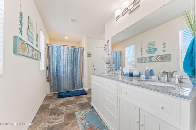 full bathroom featuring curtained shower, a sink, visible vents, baseboards, and double vanity