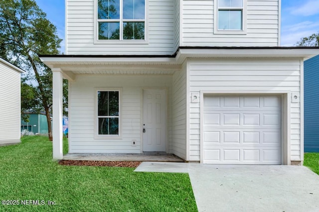 view of front of house featuring a front yard, concrete driveway, and an attached garage