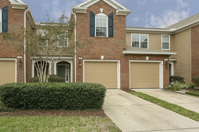 view of front of property featuring brick siding, driveway, and an attached garage