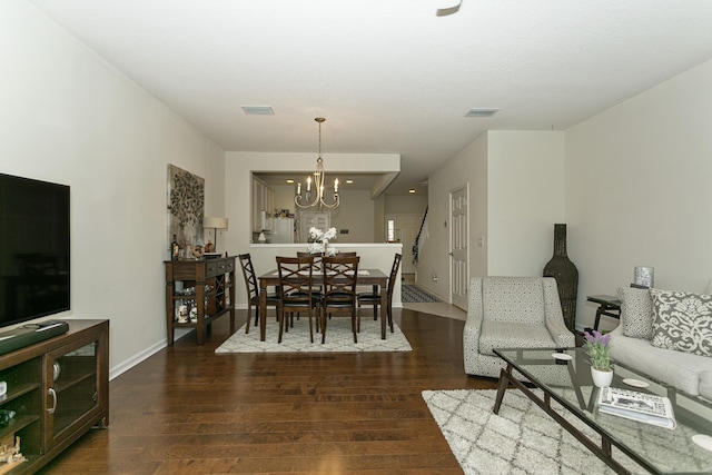 dining space with a notable chandelier, visible vents, baseboards, and wood finished floors