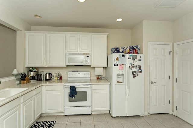 kitchen featuring a sink, white appliances, light countertops, and light tile patterned floors