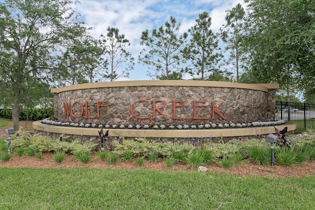 community sign featuring a yard and fence