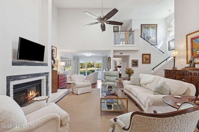 22 Walkers Ridge Dr, Ponte Vedra Beach, FL 32082 - living room with a high ceiling, stairs, a lit fireplace, and a ceiling fan