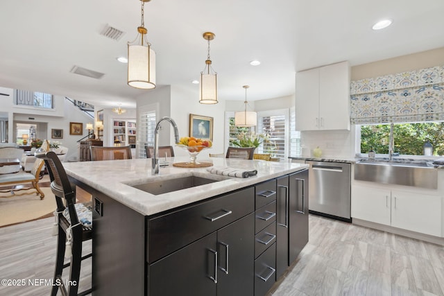 22 Walkers Ridge Dr, Ponte Vedra Beach, FL 32082 - kitchen with stainless steel dishwasher, white cabinetry, a center island with sink, recessed lighting, and tasteful backsplash