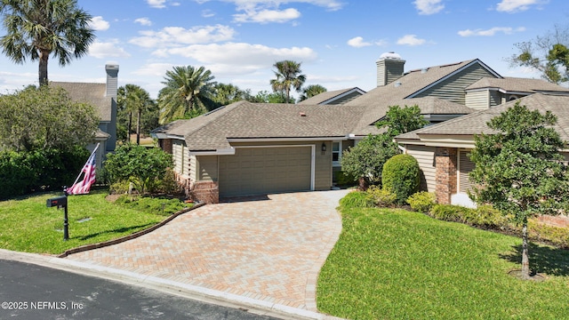 22 Walkers Ridge Dr, Ponte Vedra Beach, FL 32082 - view of front of house featuring an attached garage, decorative driveway, roof with shingles, a front yard, and a chimney