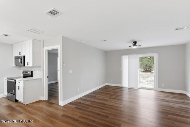 spare room with visible vents, baseboards, and wood finished floors