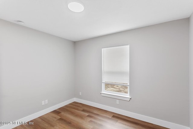 empty room with baseboards and wood finished floors
