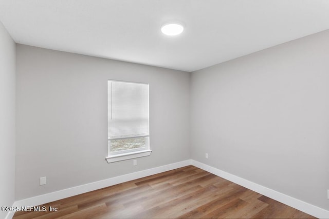 empty room with baseboards and wood finished floors