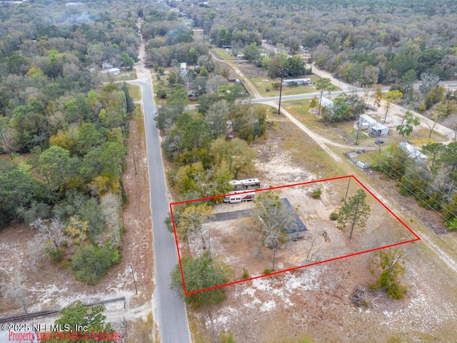 birds eye view of property with a view of trees