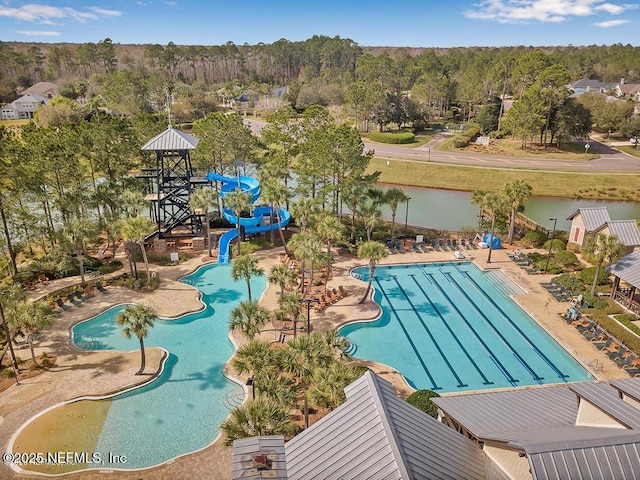 community pool featuring a water view, a water slide, and a patio