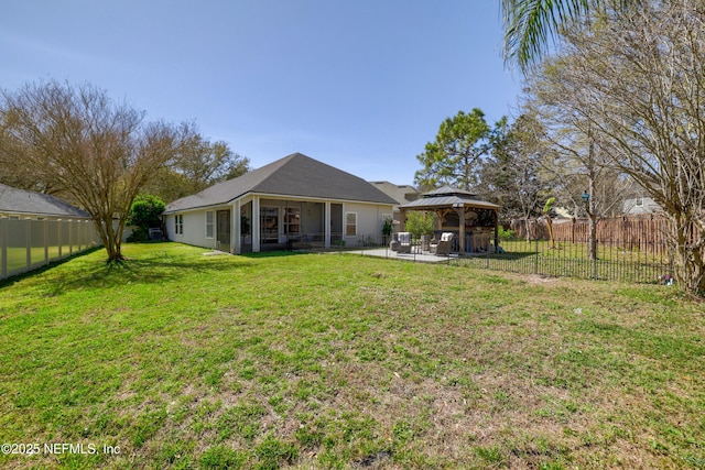 rear view of property with a gazebo, a lawn, a patio area, and a fenced backyard