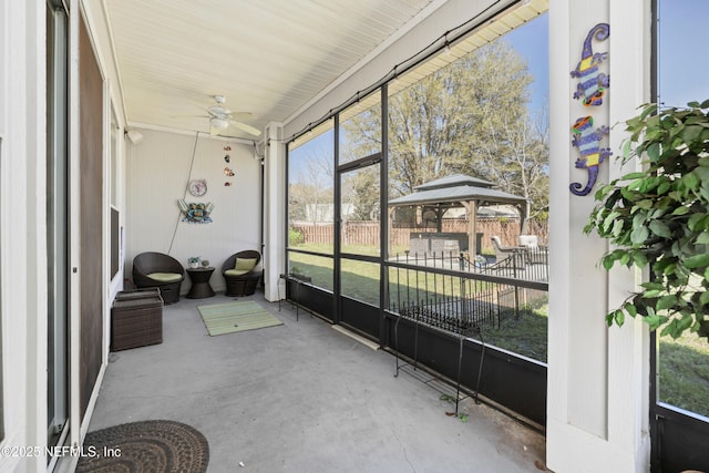 sunroom / solarium featuring a ceiling fan