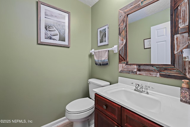 half bath featuring toilet, baseboards, a textured ceiling, and vanity