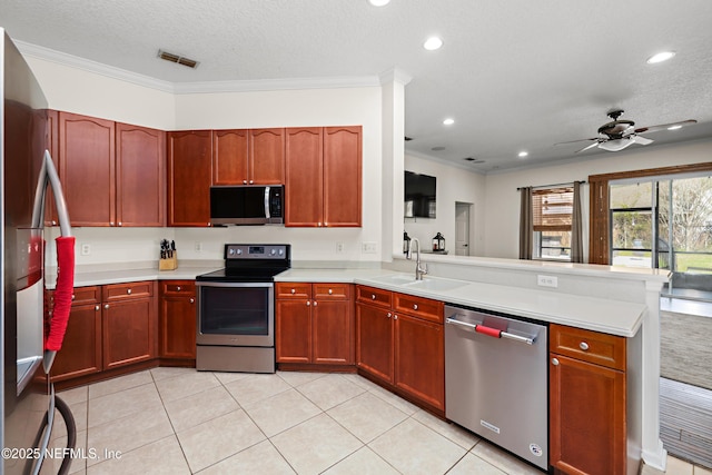 kitchen featuring stainless steel appliances, light countertops, visible vents, a sink, and a peninsula