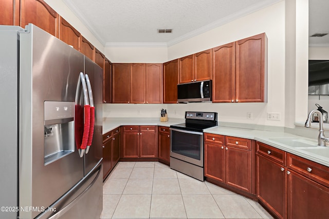 kitchen with light tile patterned floors, a sink, visible vents, ornamental molding, and appliances with stainless steel finishes