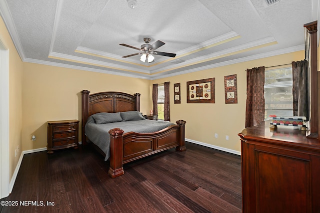 bedroom featuring dark wood-type flooring, a tray ceiling, and a textured ceiling