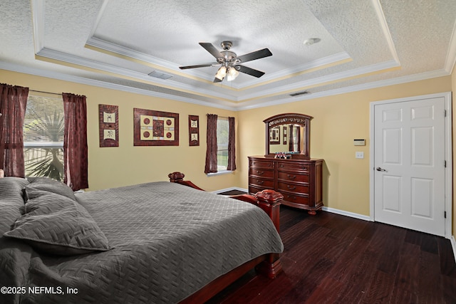 bedroom featuring a textured ceiling, dark wood finished floors, a raised ceiling, and visible vents