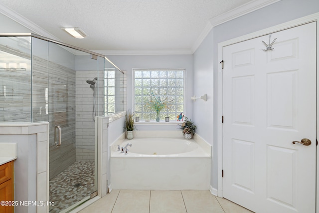 bathroom featuring crown molding, vanity, a textured ceiling, tile patterned flooring, and a bath