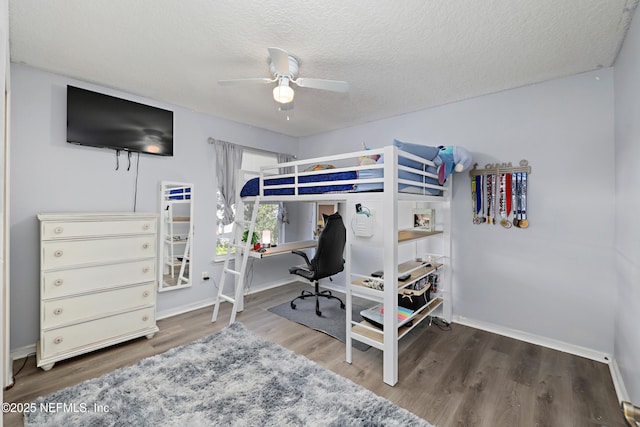 bedroom featuring a textured ceiling, ceiling fan, wood finished floors, and baseboards