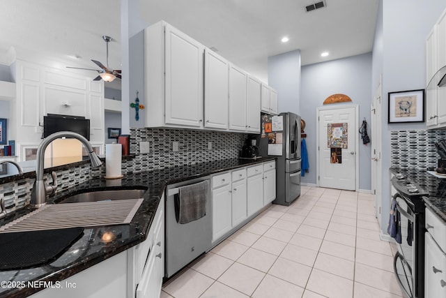 kitchen featuring tasteful backsplash, light tile patterned floors, white cabinets, and appliances with stainless steel finishes