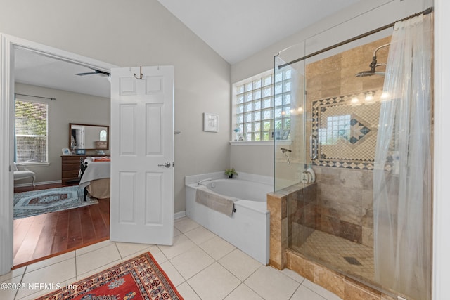 bathroom with tile patterned floors, plenty of natural light, a stall shower, and lofted ceiling